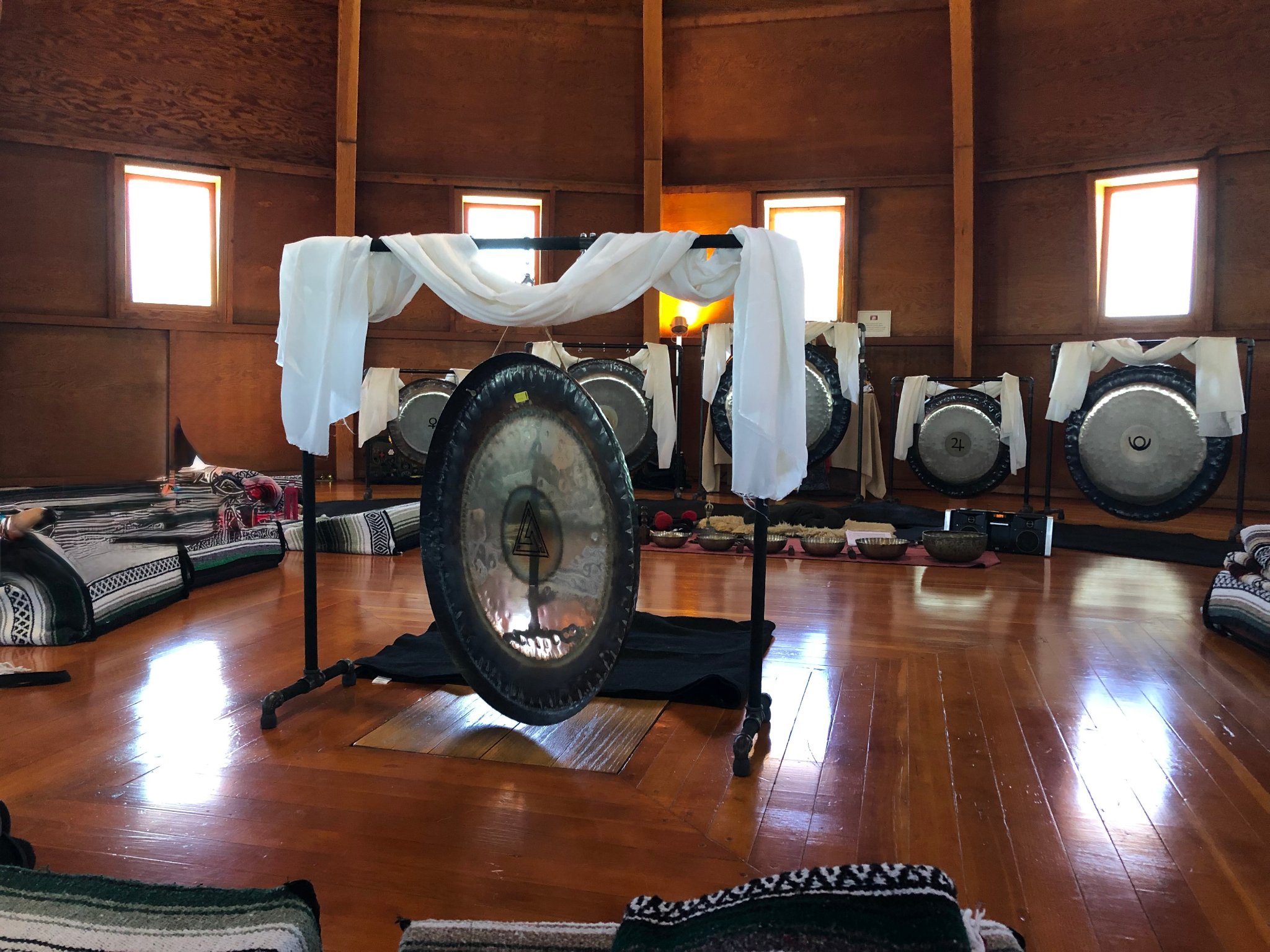 A planetary gong — large, burnished, suspended in stillness